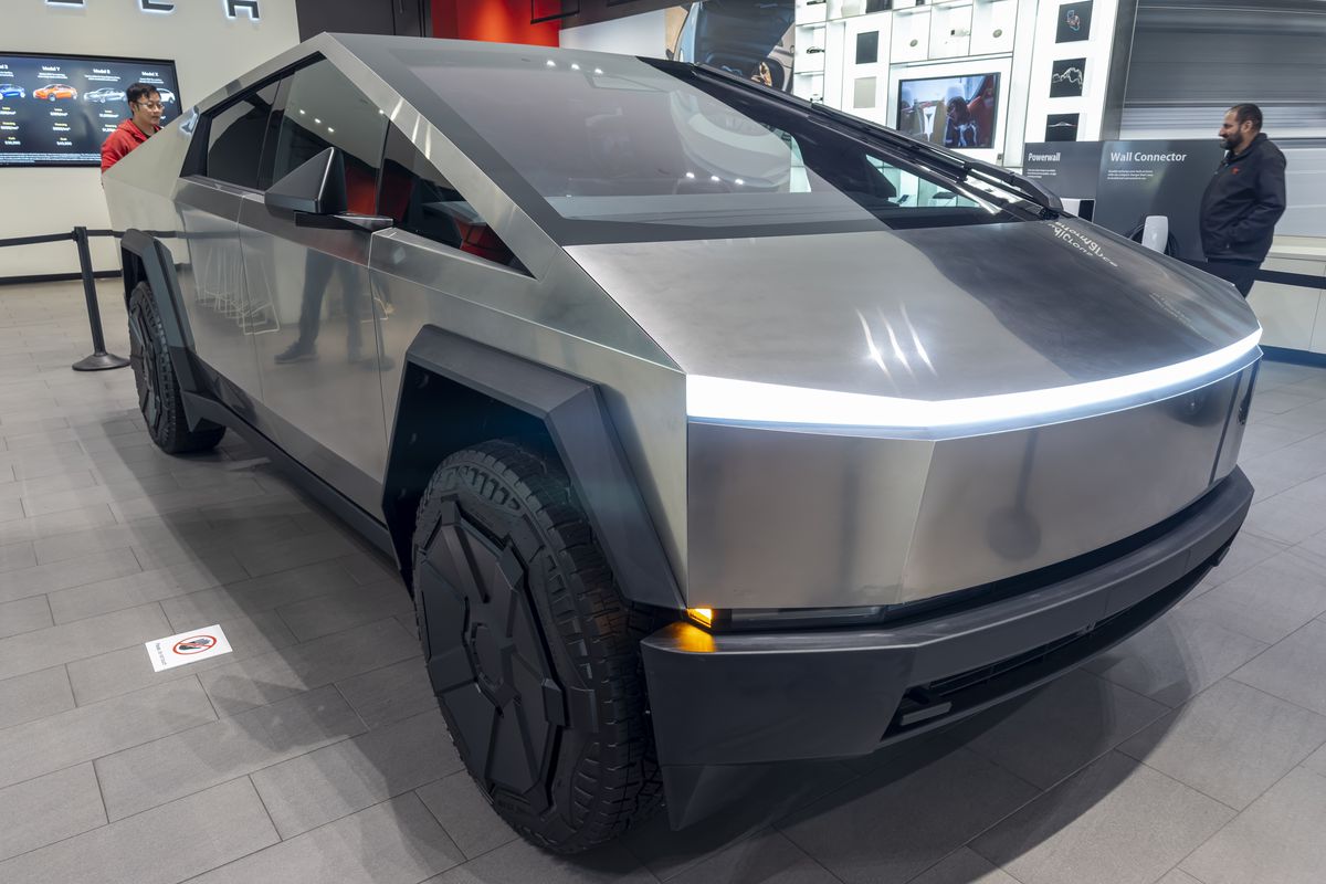 A futuristic-looking stainless steel vehicle parked in a showroom.