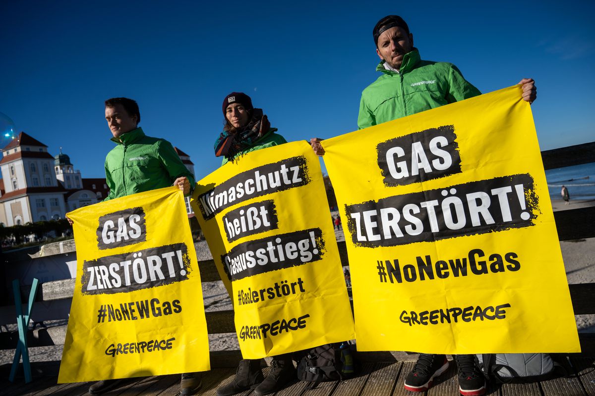 Protestors holding signs opposing new natural gas terminals in Germany.