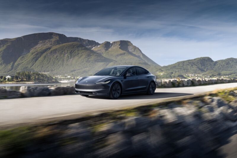 A grey Tesla model 3 rendered driving through the mountains