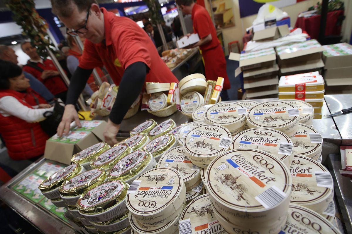 A stack of camembert cheeses in a shop.