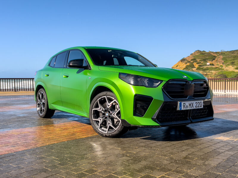 A green BMW X2 parked next to the sea