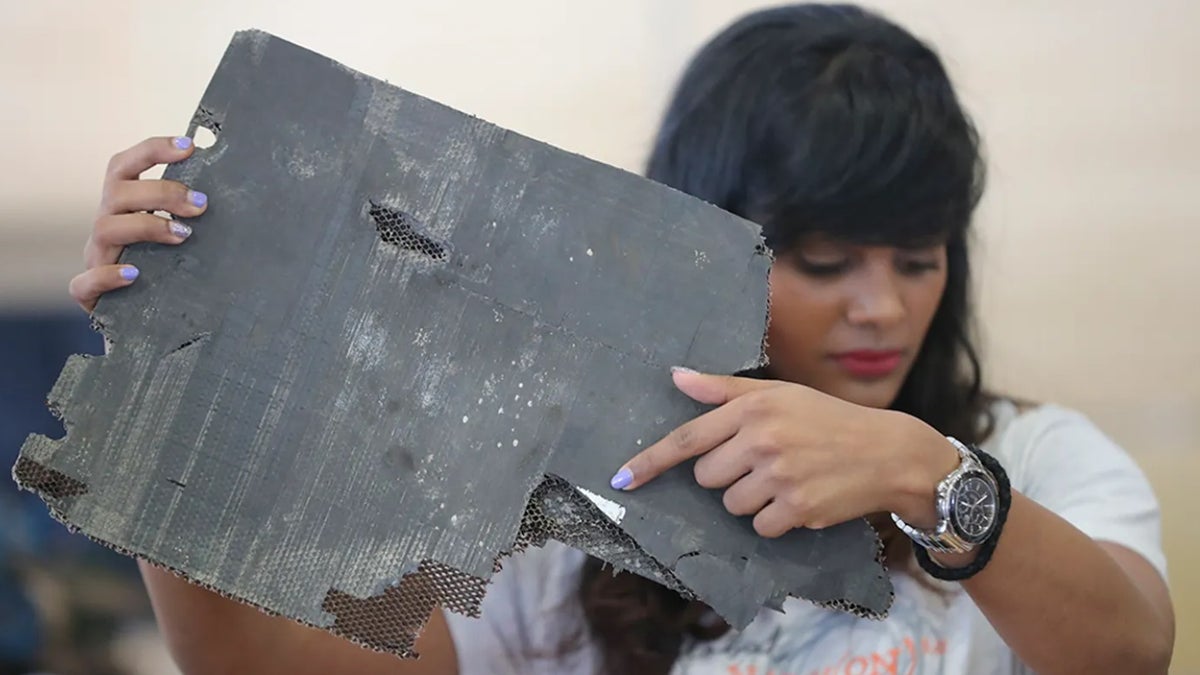 Grace Nathan, whose mother was on the ill-fated Malaysia Airlines Flight 370, shows a serial number on a piece of debris found in Madagascar that is "most likely" from MH370 at the Ministry of Transport in Putrajaya, Malaysia, Friday, Nov. 30, 2018.