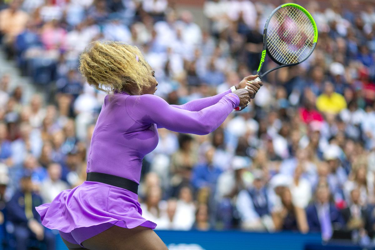 Serena Williams swinging a tennis racket on the court.