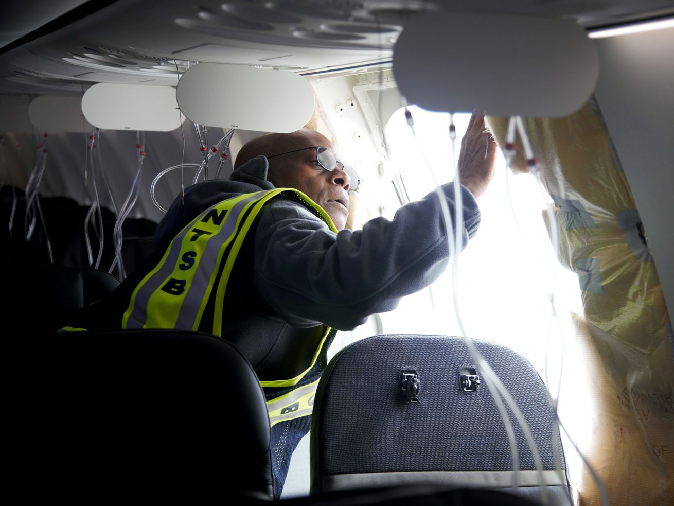 NTSB Investigator-in-Charge John Lovell examines the fuselage plug area of Alaska Airlines Flight 1282 Boeing 737-9 MAX.