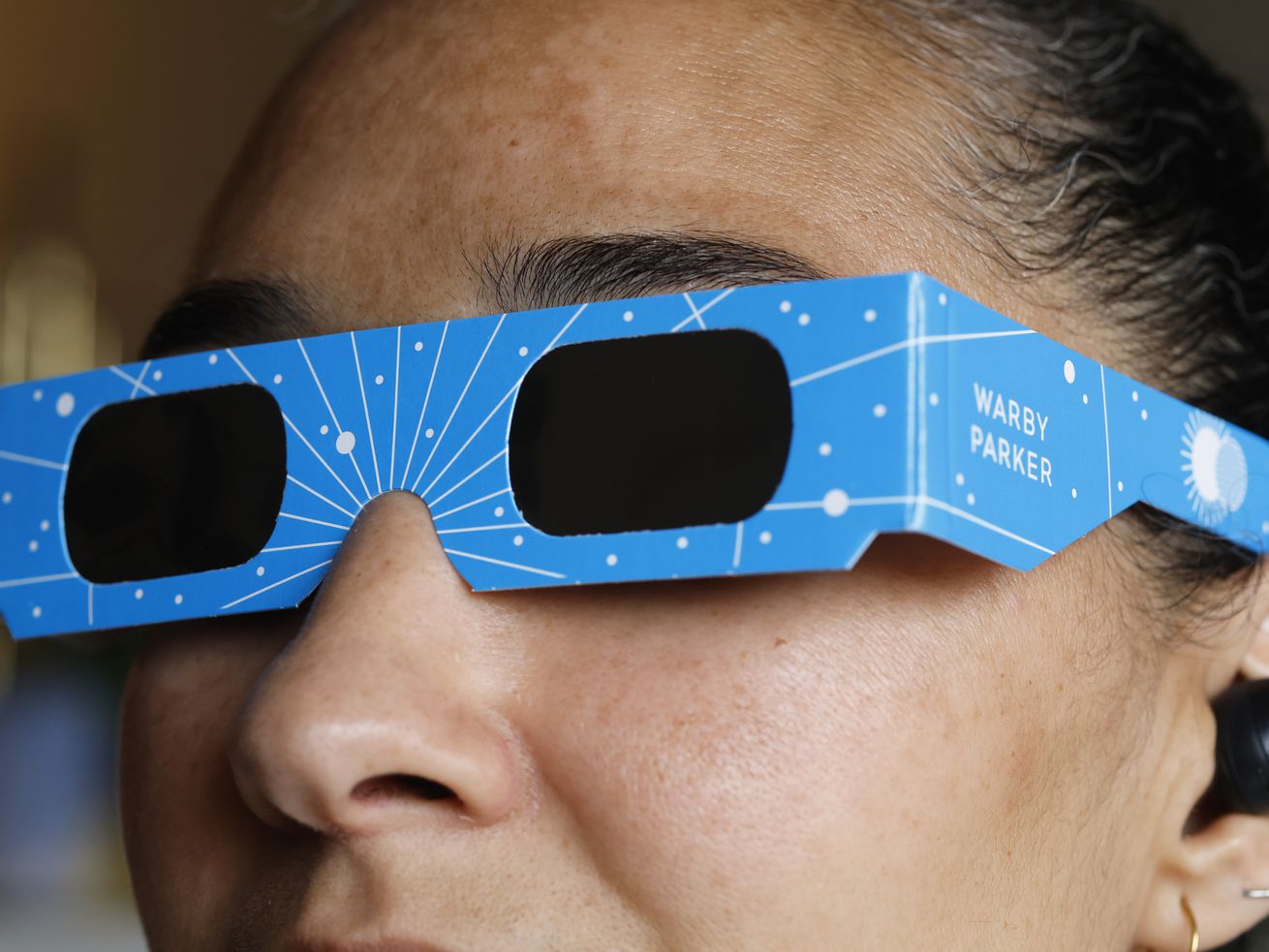 In this photo illustration, a woman models eclipse glasses from Warby Parker on April 1, 2024 in New York City.