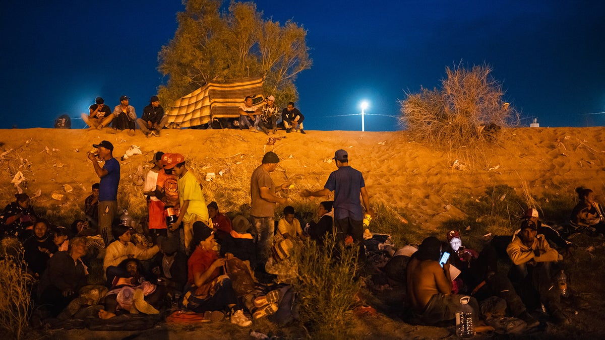 Migrants after nightfall at the border