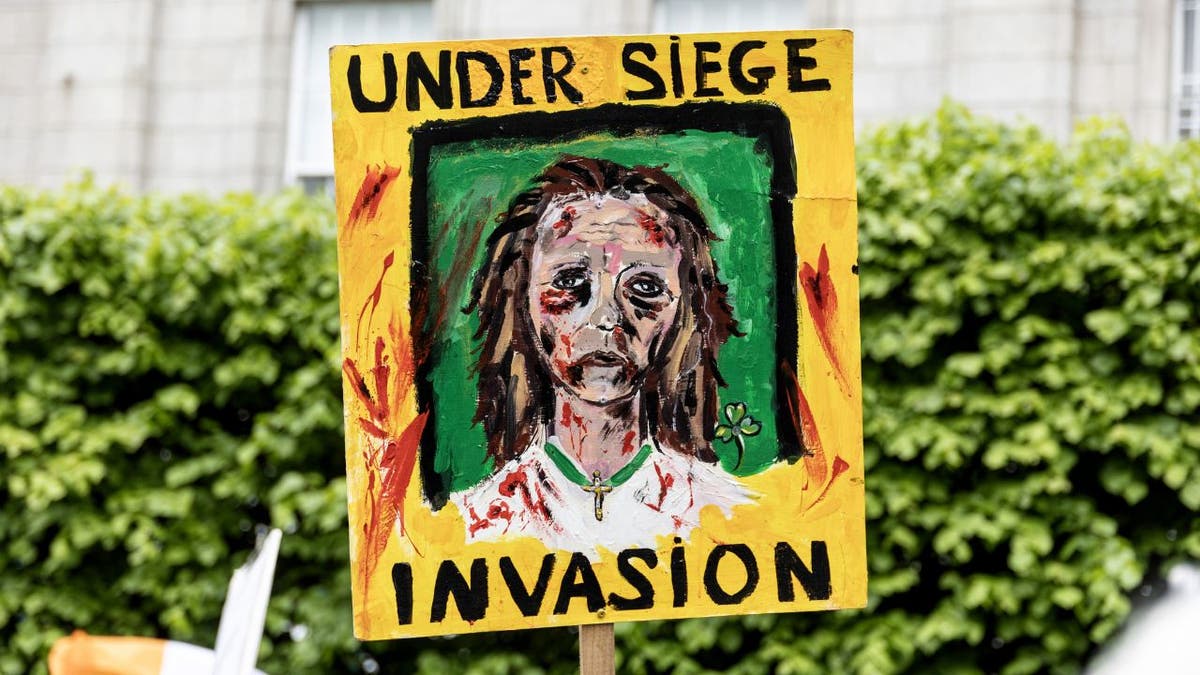 A sign at a Dublin anti-mass immigration rally reads: "Under Siege Invasion"