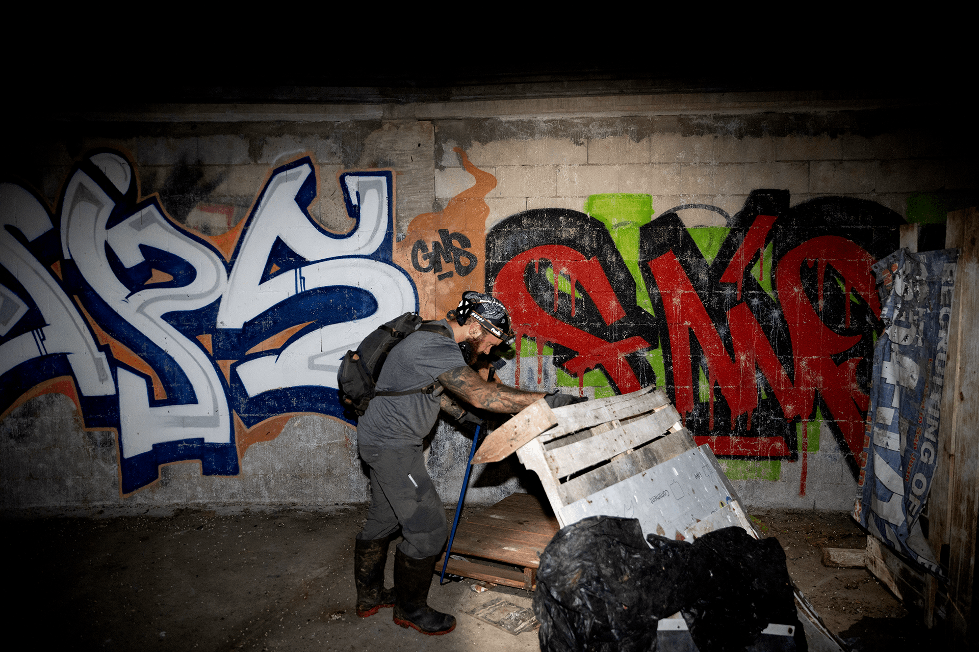 Colston peers under trash in search of a reticulated python inside an abandoned sports stadium in central Puerto Rico.