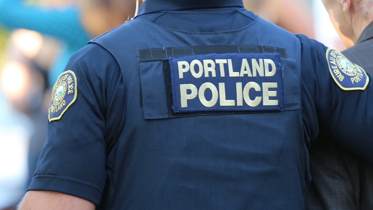Photo shows police officer wearing vest reading "Portland Police"