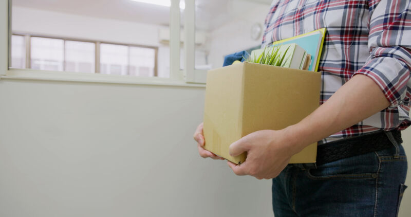 Someone holding a box with their belonging in an office