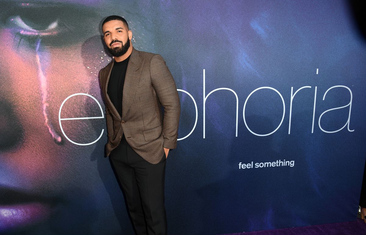Drake stands in front of a backdrop that reads “Euphoria, feel something.”
