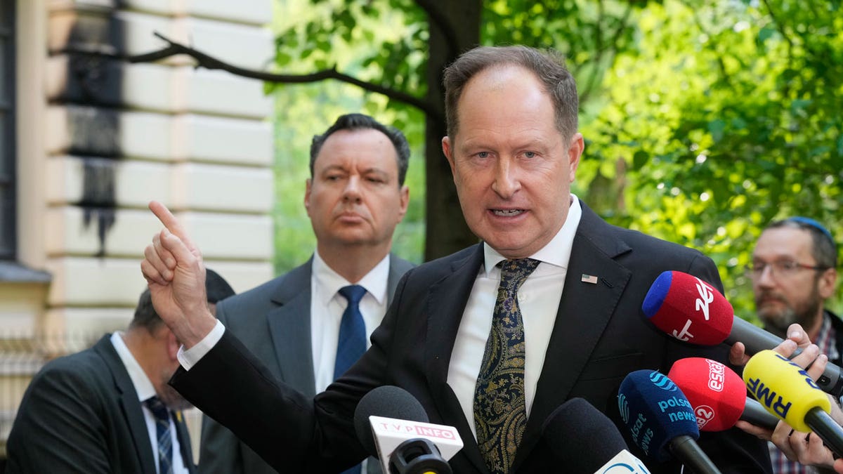 Israel's Ambassador to Poland, Yacov Livne, left, and U.S. Ambassador to Poland Mark Brzezinski, speak to reporters at a news conference in front of the Nożyk Synagogue