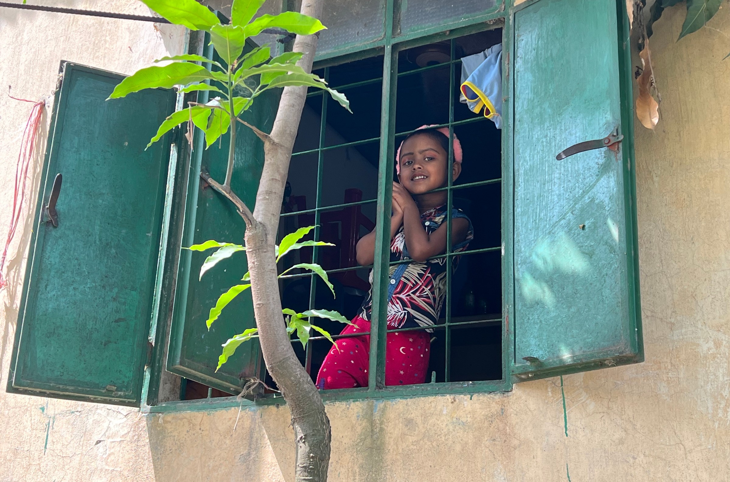 Akhter’s younger daughter, Muntaha, looks out a window. 