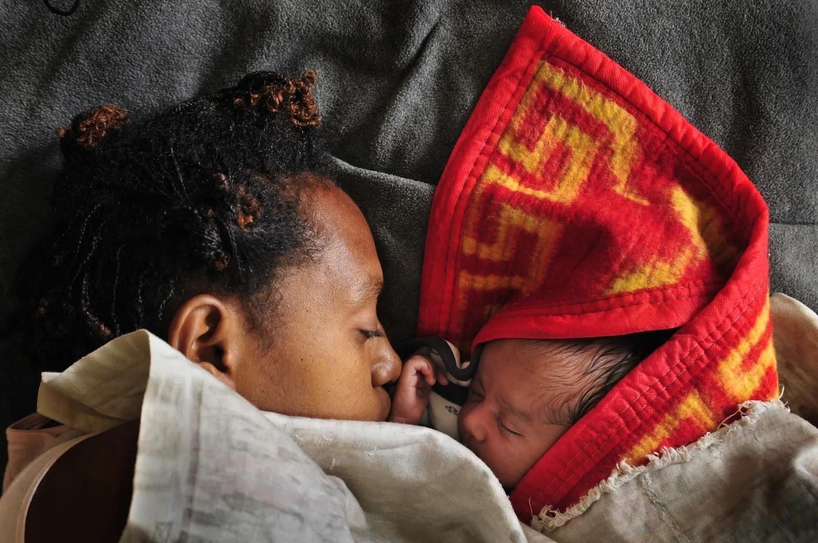 A woman sleeps with her baby in the maternity ward of a hospital in Goroka in the Eastern Highlands province of Papua New Guinea in 2009. 