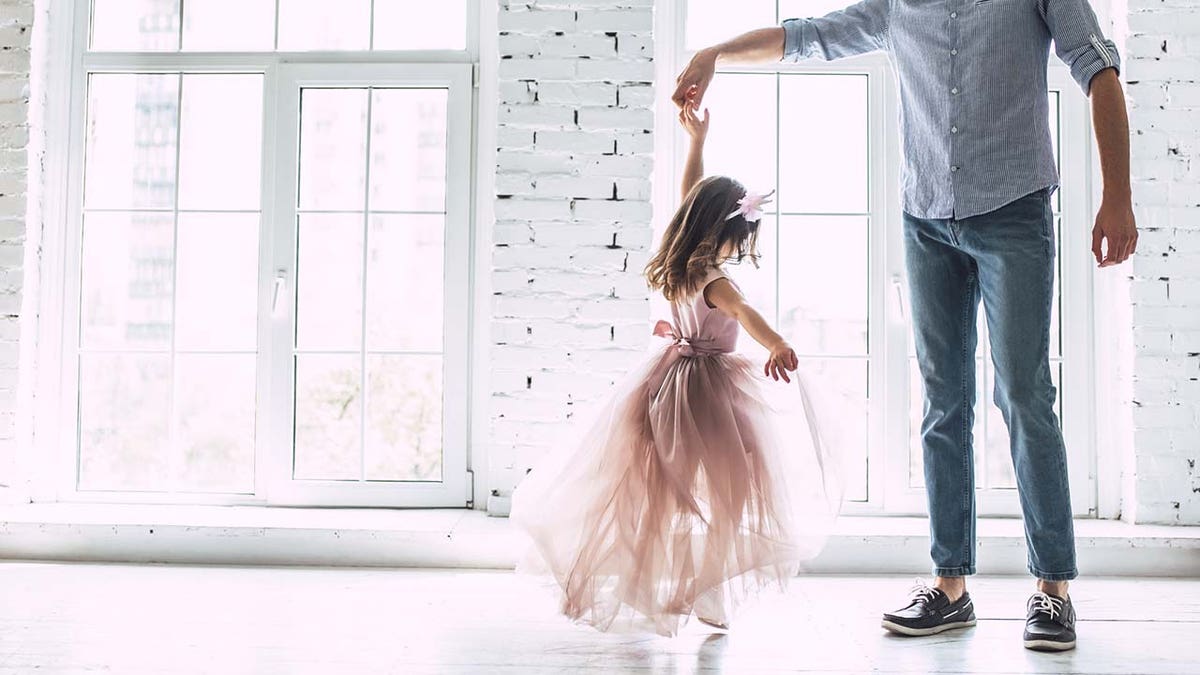dad twirls girl on dance floor