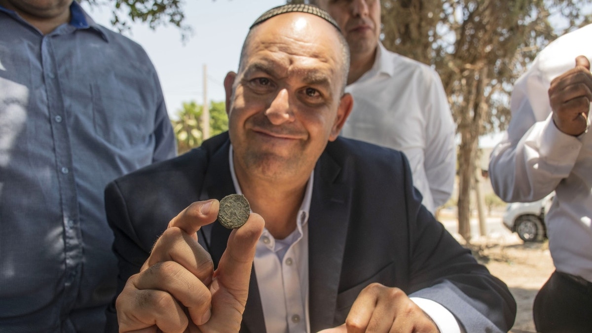 Jewish man holding ancient coin