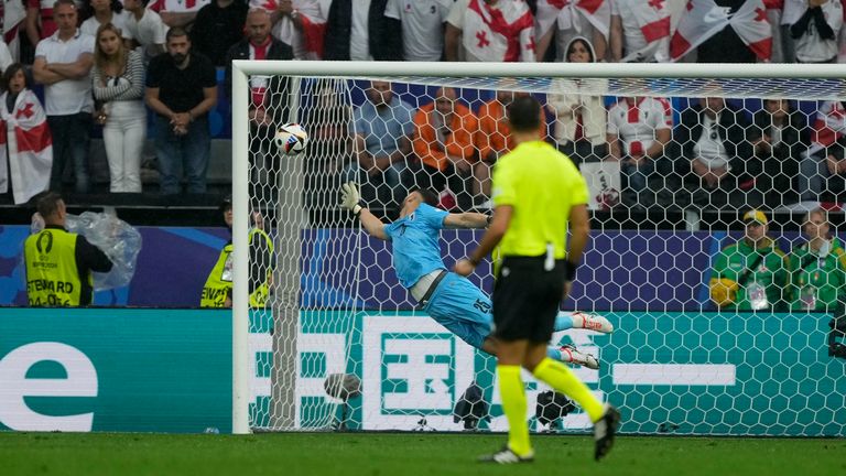 Georgia's goalkeeper Giorgi Mamardashvili jumps for the ball as Turkey's Arda Guler scores his side's second goal during a Group F match between Turkey and Georgia at the Euro 2024 soccer tournament in Dortmund, Germany, Tuesday, June 18, 2024. (AP Photo/Martin Meissner)