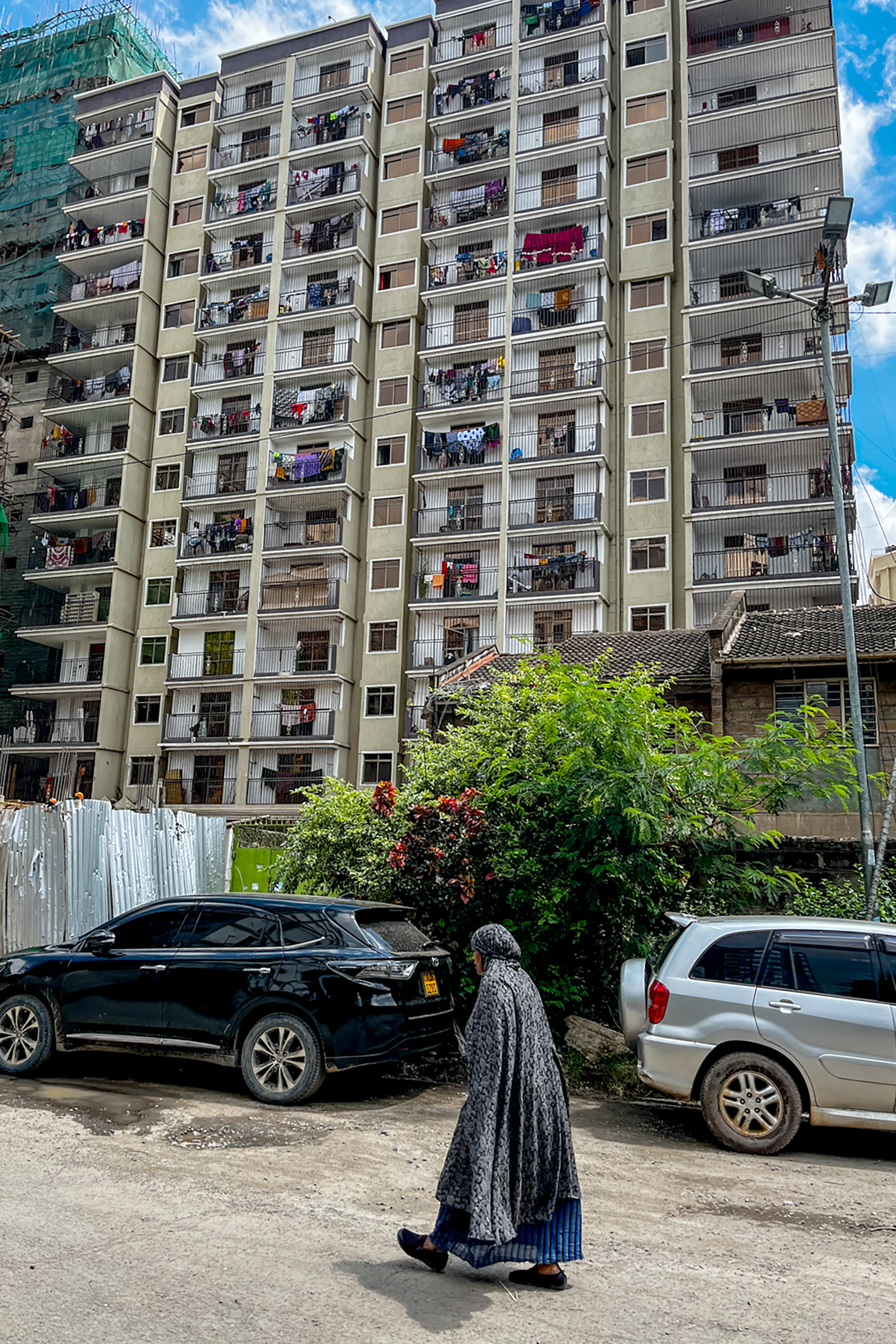 A woman walks by an apartment building in Nairobi’s immigrant-infused neighborhood of Eastleigh.