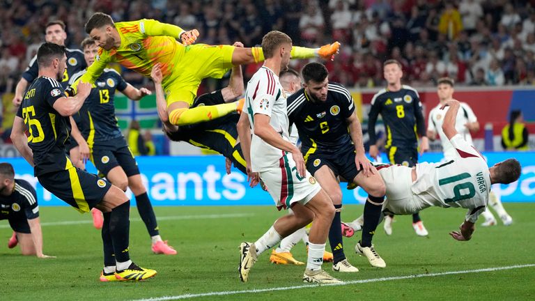 Hungary's Barnabas Varga, right, falls during an action in front of the goal during a Group A match between Scotland and Hungary at the Euro 2024 soccer tournament in Stuttgart, Germany, Sunday, June 23, 2024. (AP Photo/Antonio Calanni)