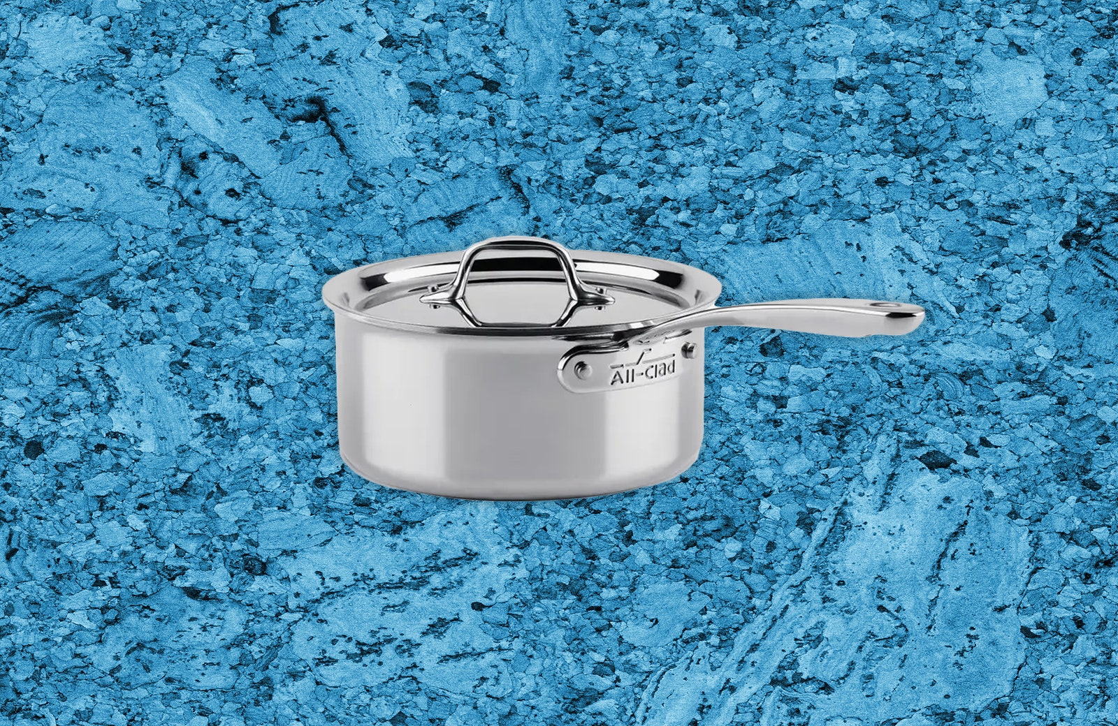 Silver sauce pan with lid on blue textured background