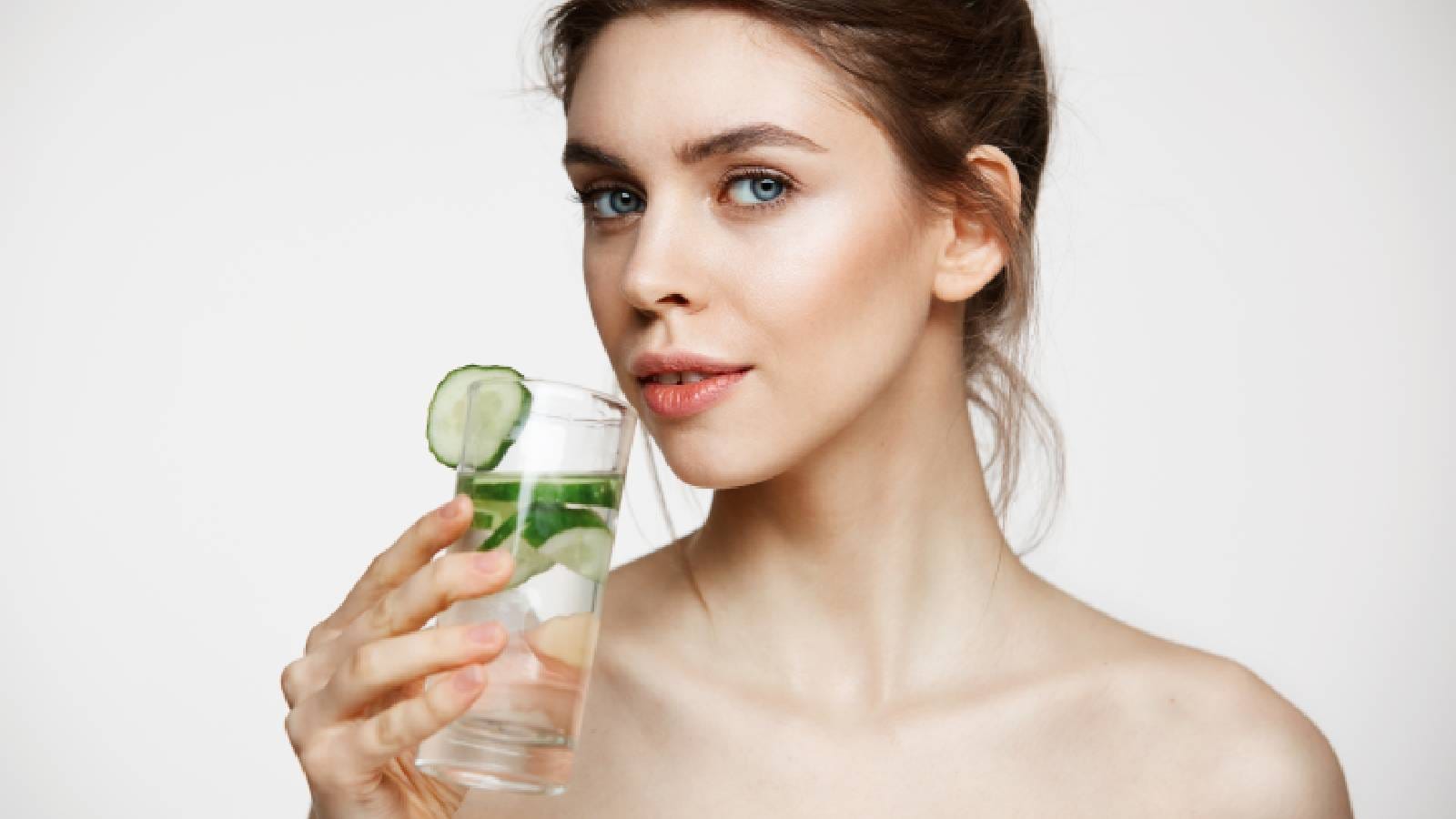 A woman drinking cucumber water
