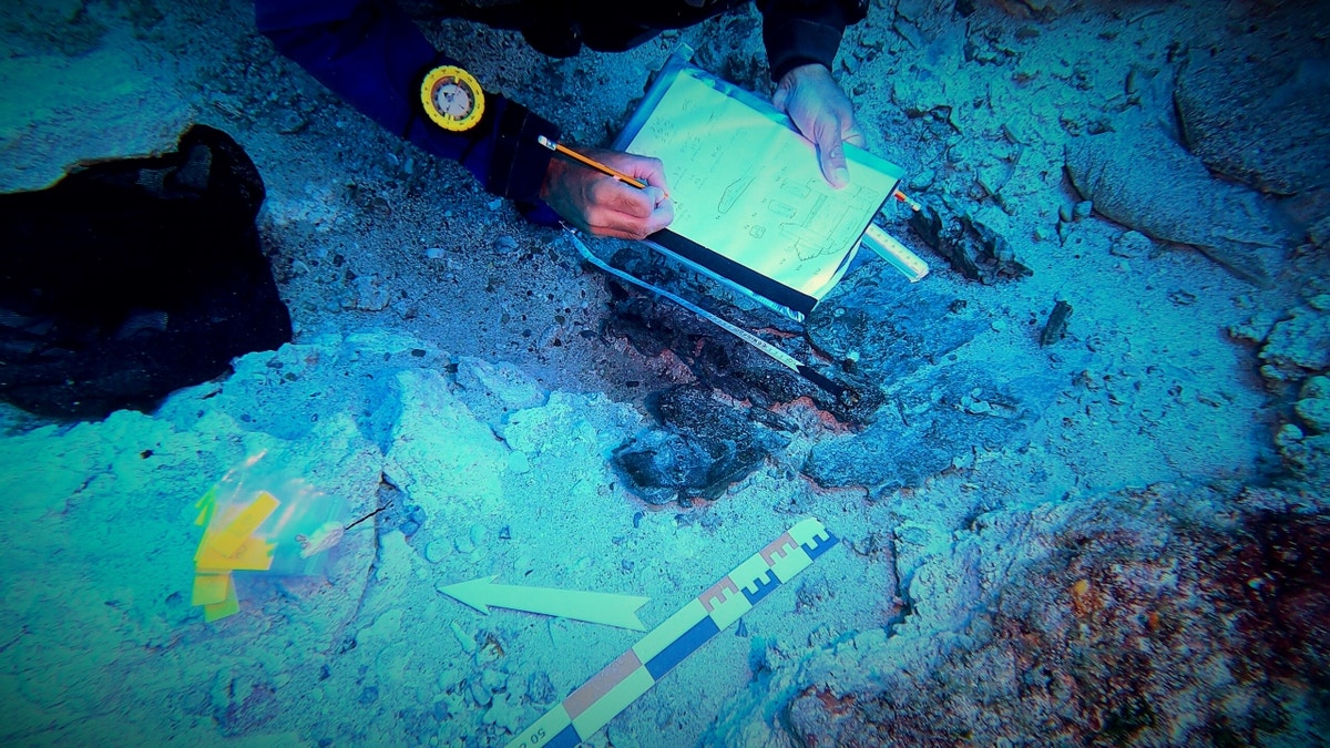 Diver writing down notes underwater