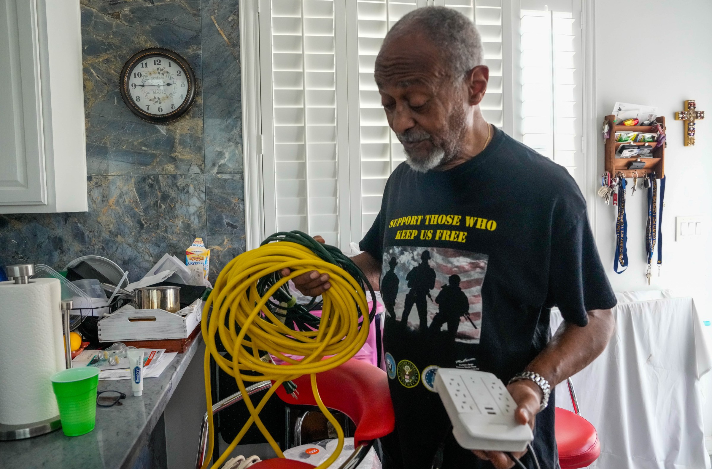 Jose Grinan, 71, holds extension cables he used for his generator to power his home after Hurricane Beryl caused major power outages.