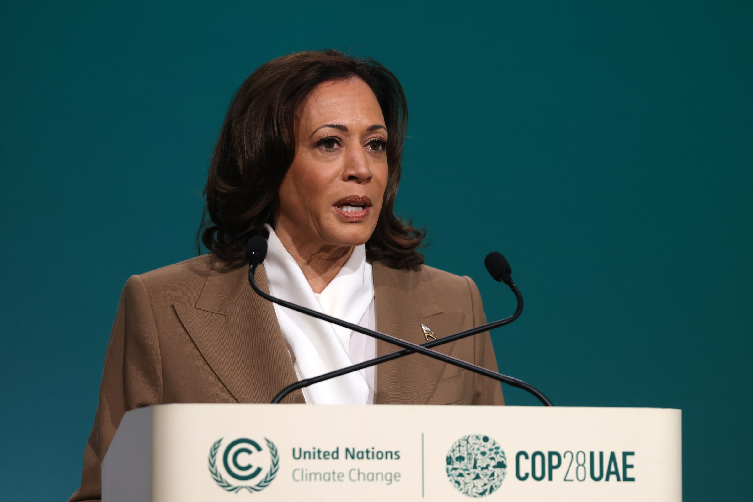 Kamala Harris standing at a lectern that has United Nations Climate Change COP28 UAE.