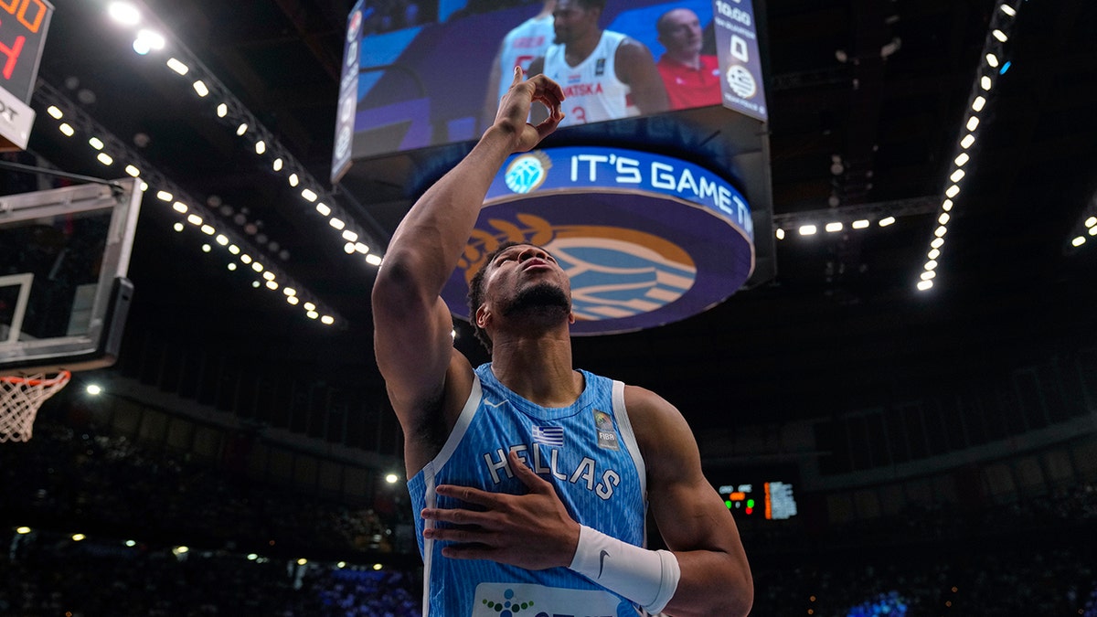 Giannis Antetokounmpo points up on court