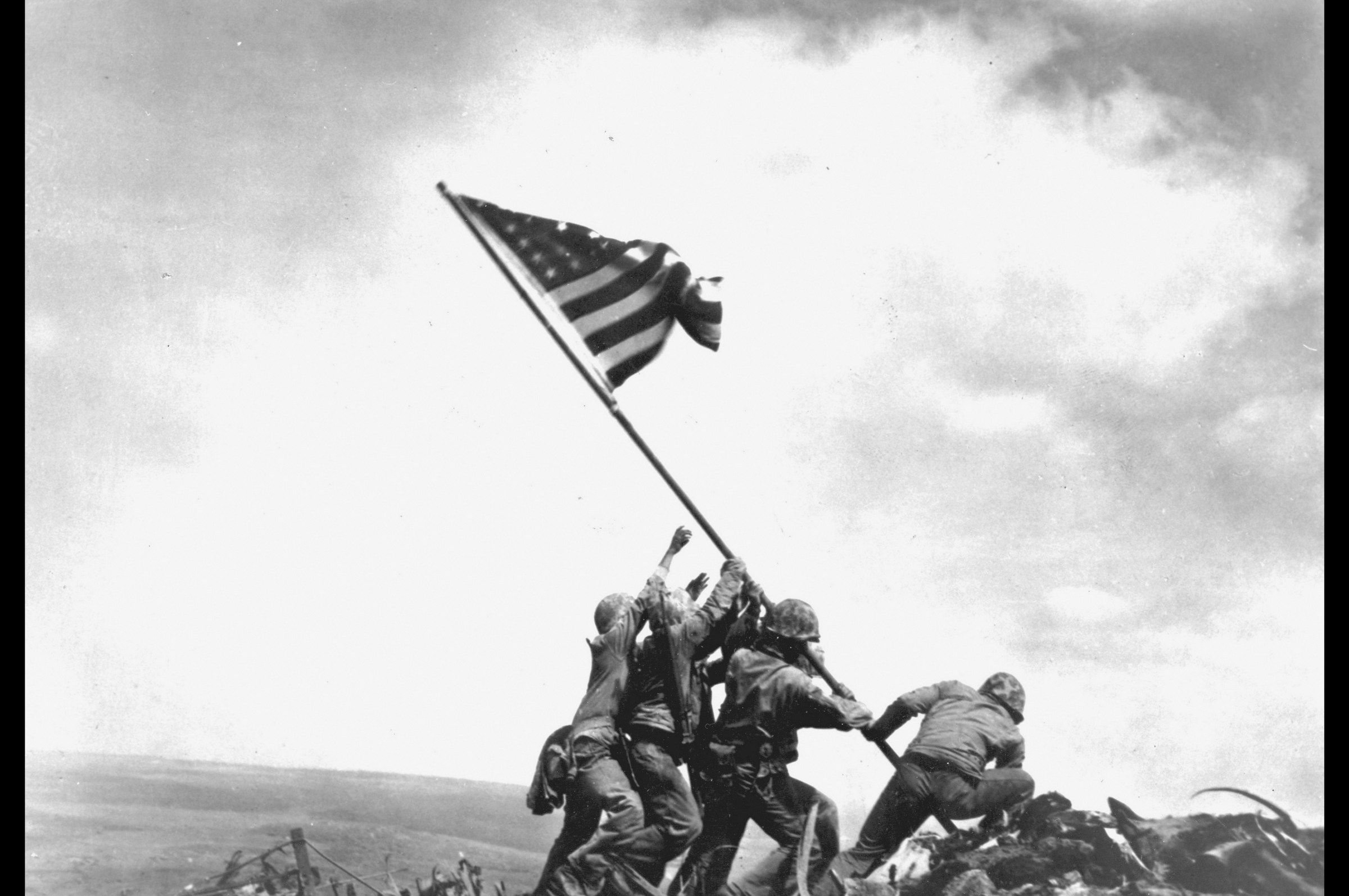 Members of the United States Marine Corps 5th Division raise an American flag on Mount Suribachi during the Battle of Iwo Jima, February 23, 1945.