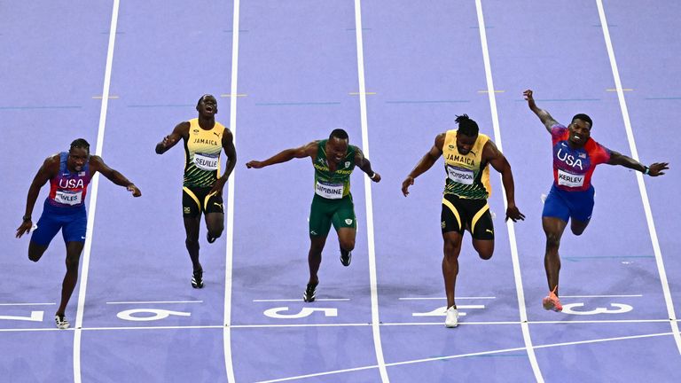 Noah Lyles (L) crosses the finish line in the men's 100m final - 