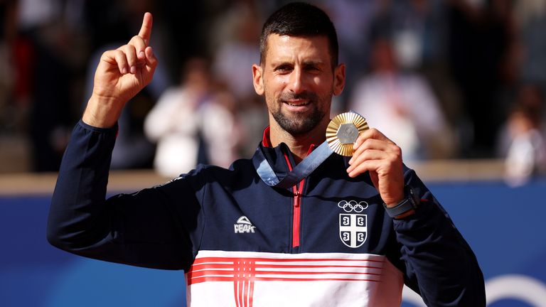 Gold medalist Novak Djokovic of Team Serbia celebrates on the podium during the Tennis Men's Singles medal ceremony after the Tennis Men's Singles Gold medal match on day nine of the Olympic Games Paris 2024 at Roland Garros on August 04, 2024 in Paris, France. (Photo by Clive Brunskill/Getty Images)