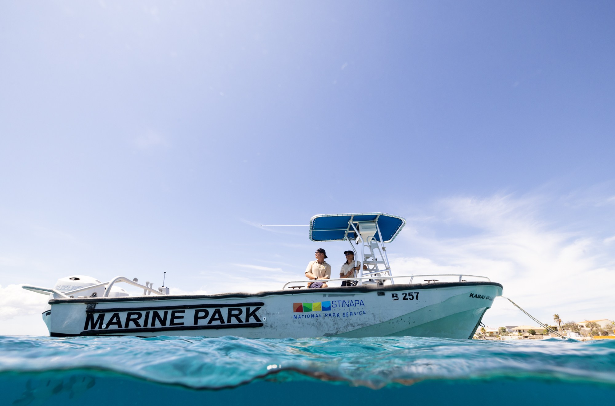 A boat above the ocean waterline, the side of which reads “Marine Park”