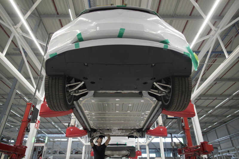 An employee works beneath a Tesla Model X sports utility vehicle (SUV) during assembly for the European market at the Tesla Motors Inc. factory in Tilburg, Netherlands, on Friday, Dec. 9, 2016. A boom in electric vehicles made by the likes of Tesla could erode as much as 10 percent of global gasoline demand by 2035, according to the oil industry consultant Wood Mackenzie Ltd. Photographer: Jasper Juinen/Bloomberg via Getty Images