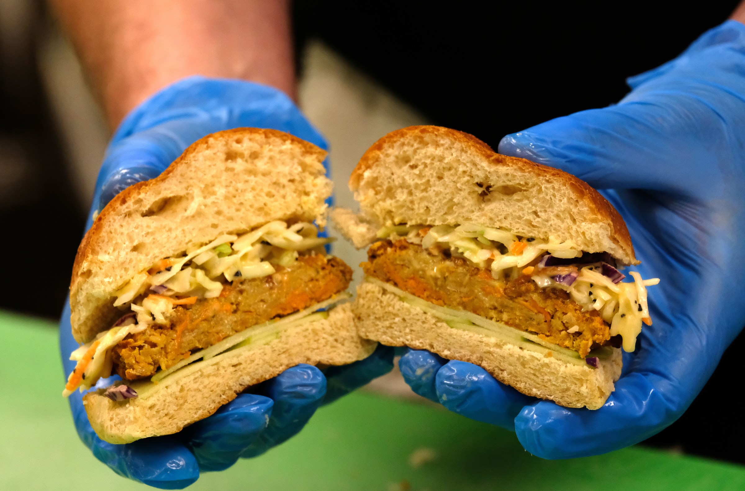 A school lunch employee in the San Luis Obispo, California, area shows off a lentil burger.