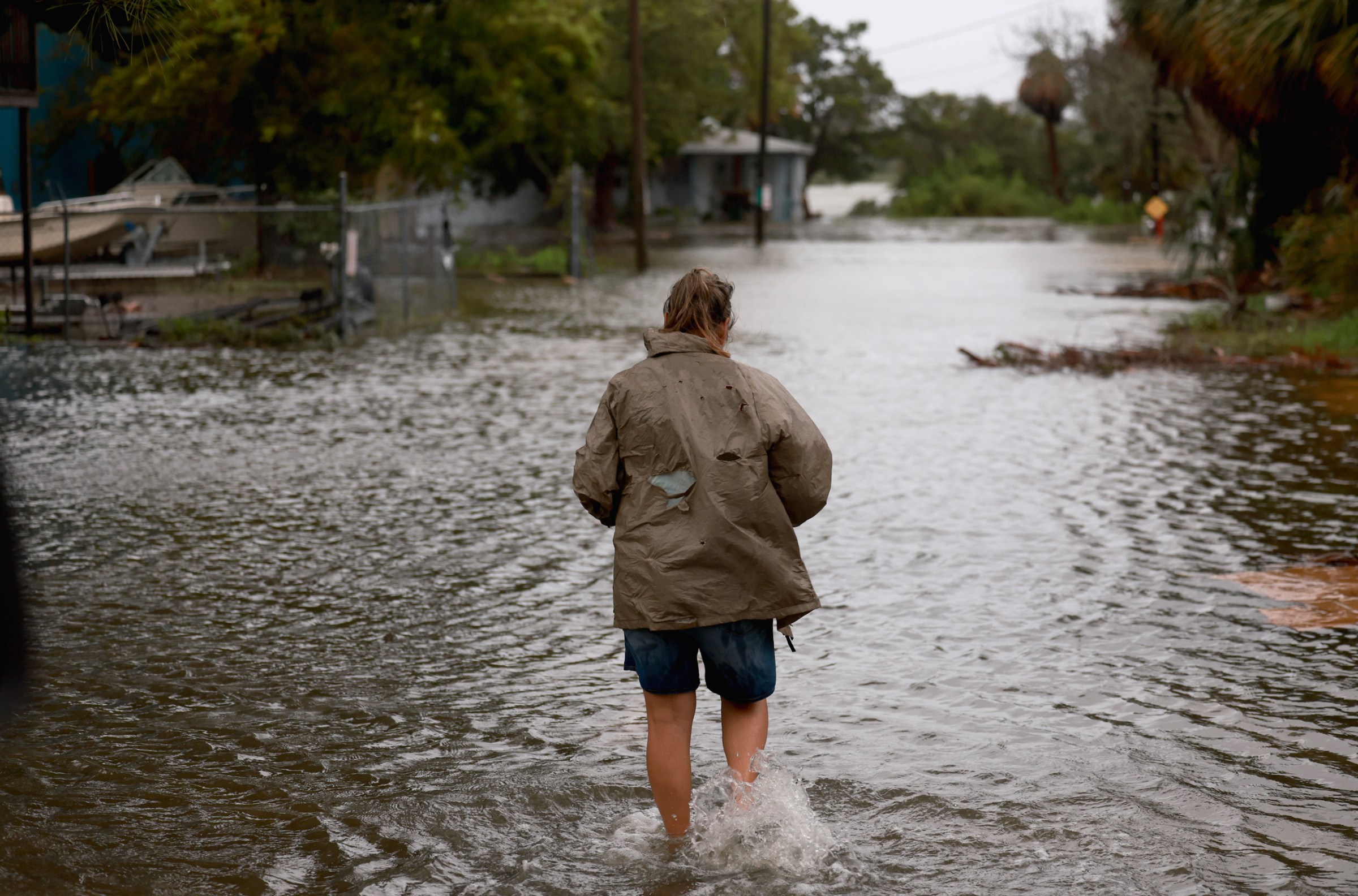 A person walks through a flooded street caused by the rain and storm surge from Tropical Storm Debby on Monday in Cedar Key, Florida.