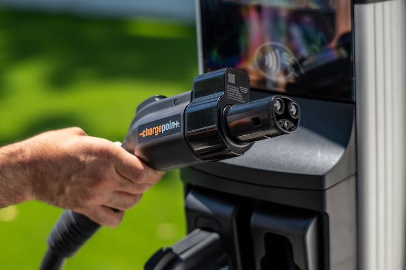 A person holds an EV charging plug