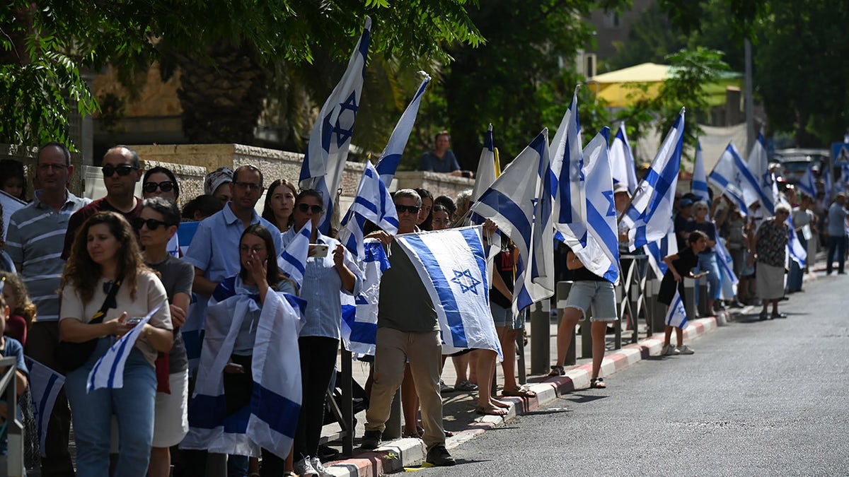 Mourners carrying Israel flags