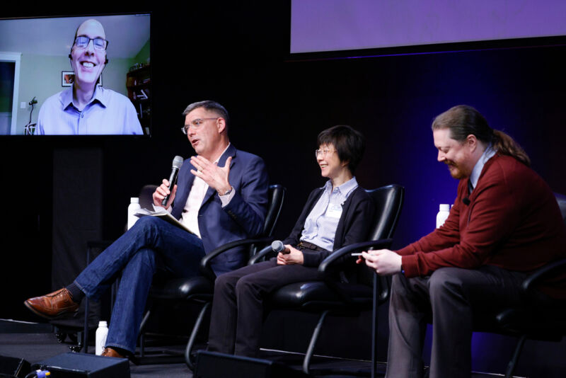 Photograph of participants in a panel on stage