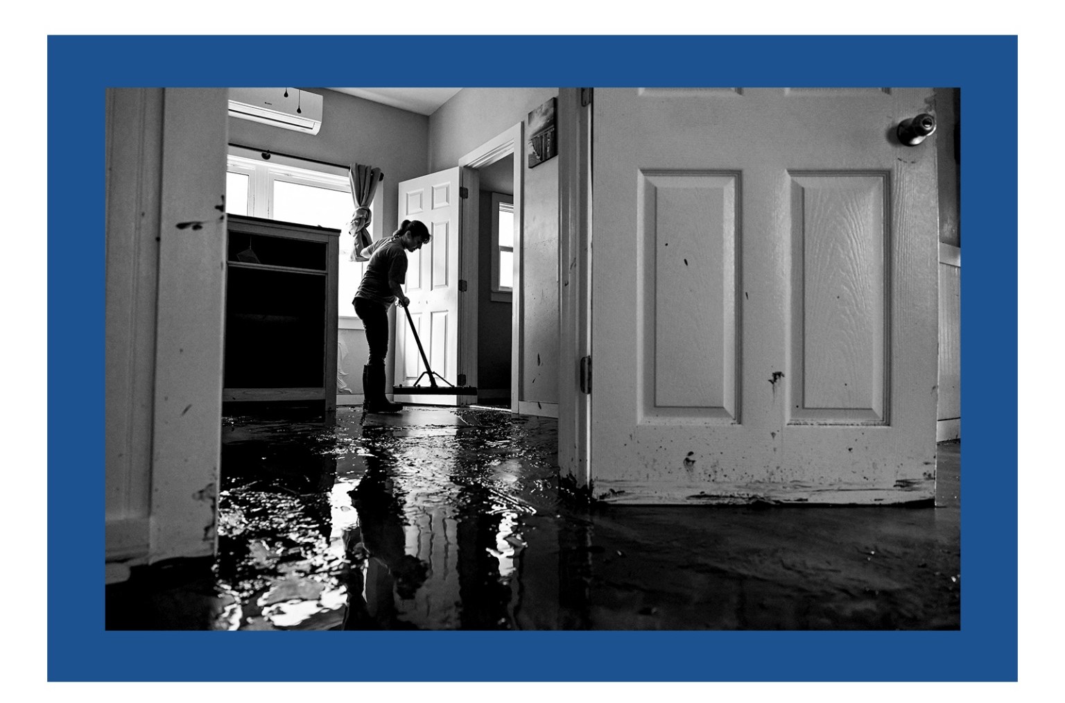 A woman cleaning her house after Hurricane Helene made landfall in Cedar Key, Florida.