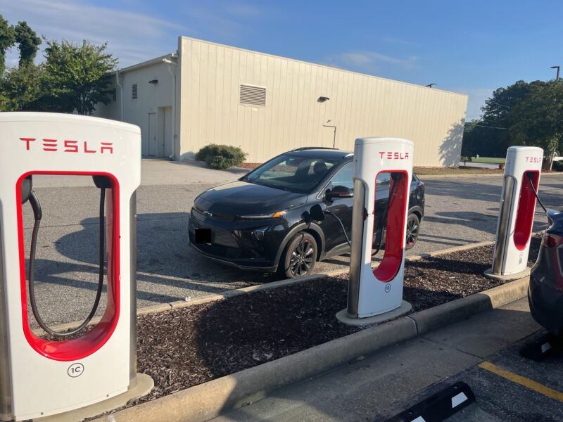 Bolt awkwardly parked sideways behind some Tesla stations