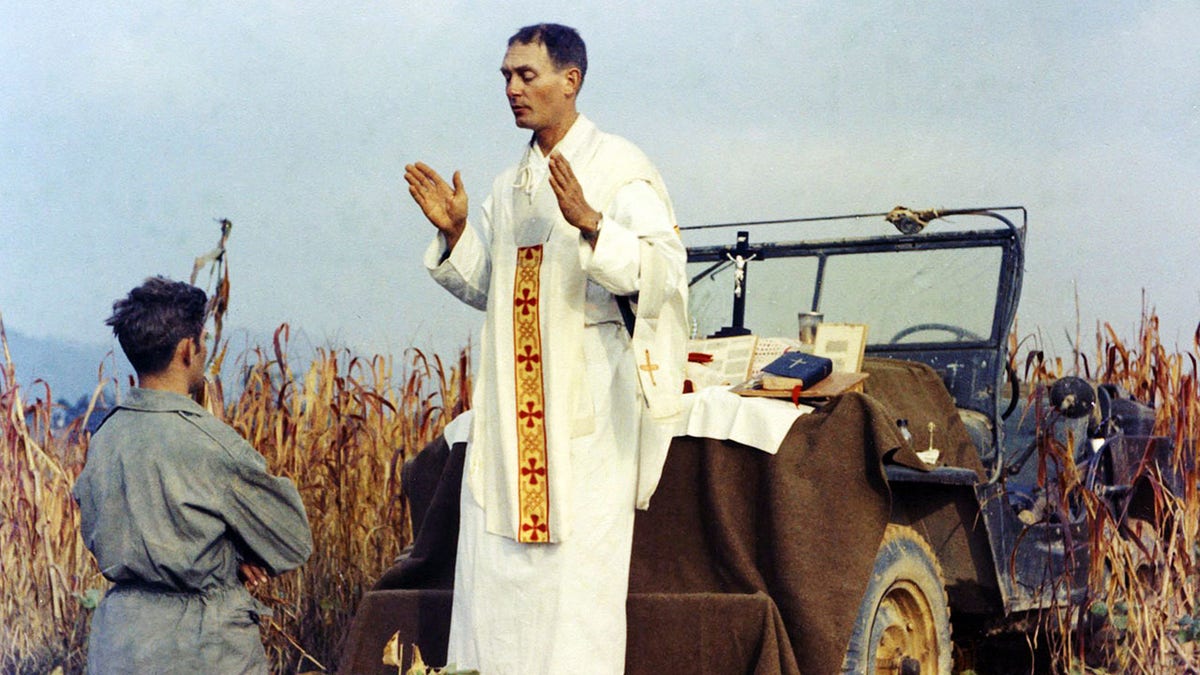 Man celebrating Mass on the hood of a Jeep