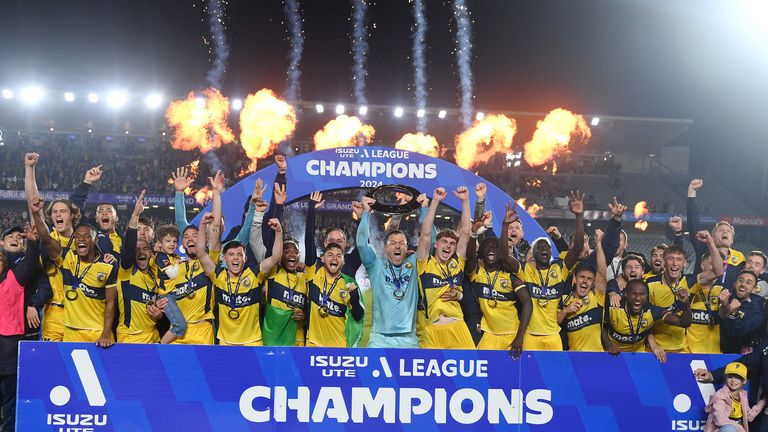 Central Coast Mariners captain Danny Vukovic (C) holds the trophy as players celebrate victory after the A-League Men...s grand final football match between Central Coast Mariners and Melbourne Victory at Industree Group Stadium in Gosford on May 25, 2024. (Photo by Izhar KHAN / AFP) / -- IMAGE RESTRICTED TO EDITORIAL USE - STRICTLY NO COMMERCIAL USE ...