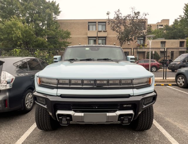 A Hummer EV SUV seen head-on, in a parking space.