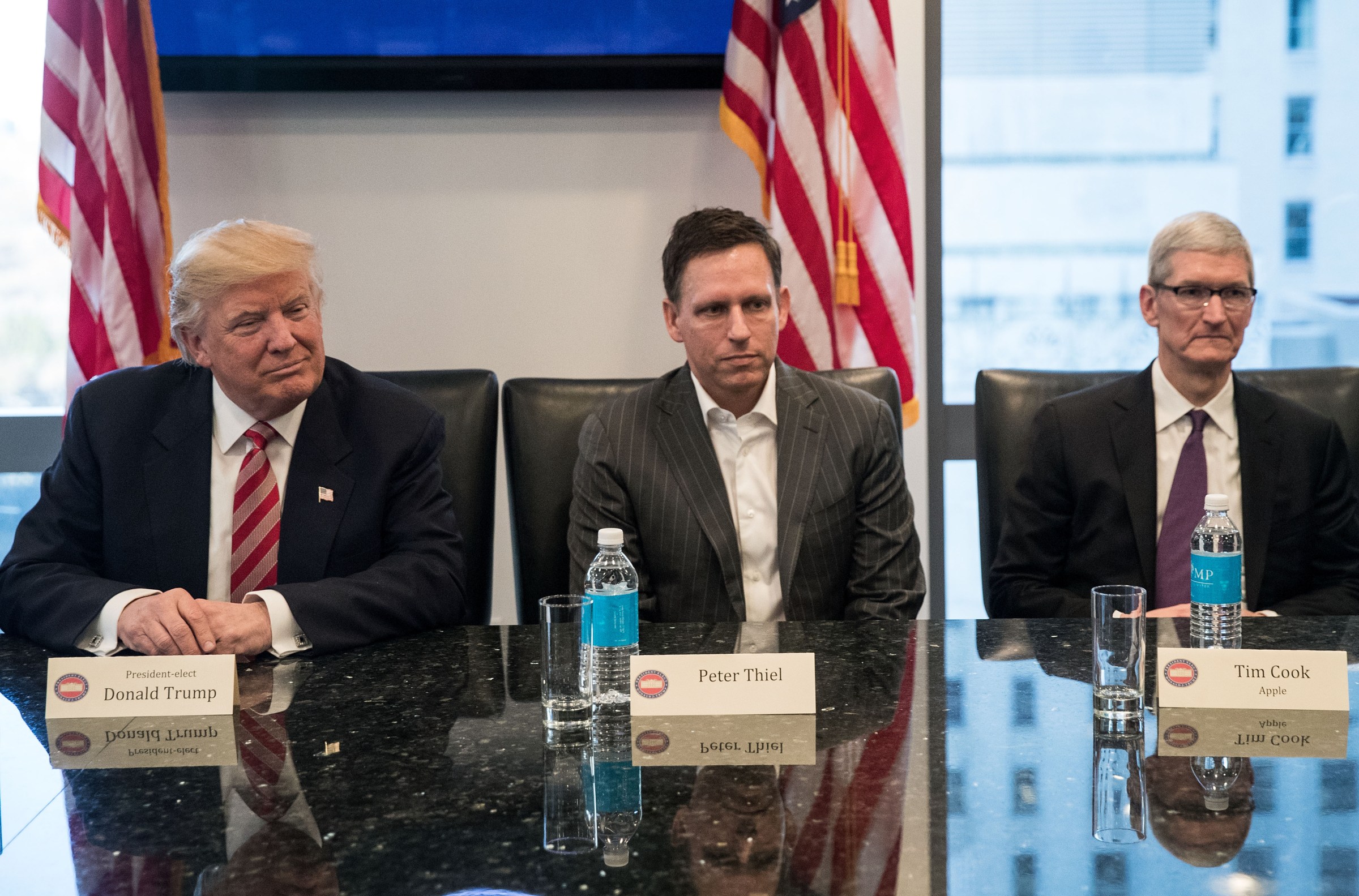 Donald Trump, Peter Thiel, and Tim Cook sit at a table, looking awkward.