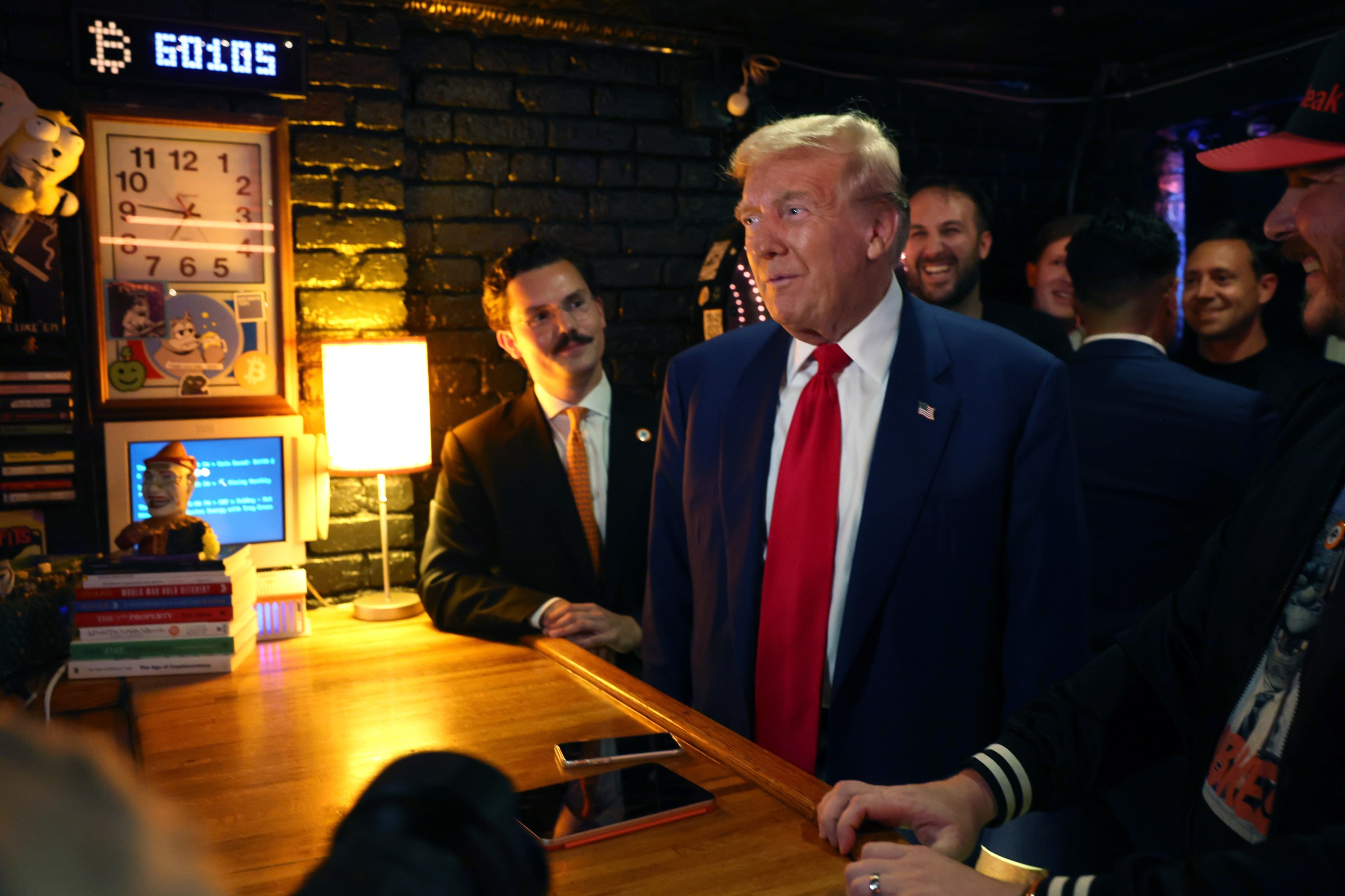 Donald Trump at crowded crypto-themed bar.