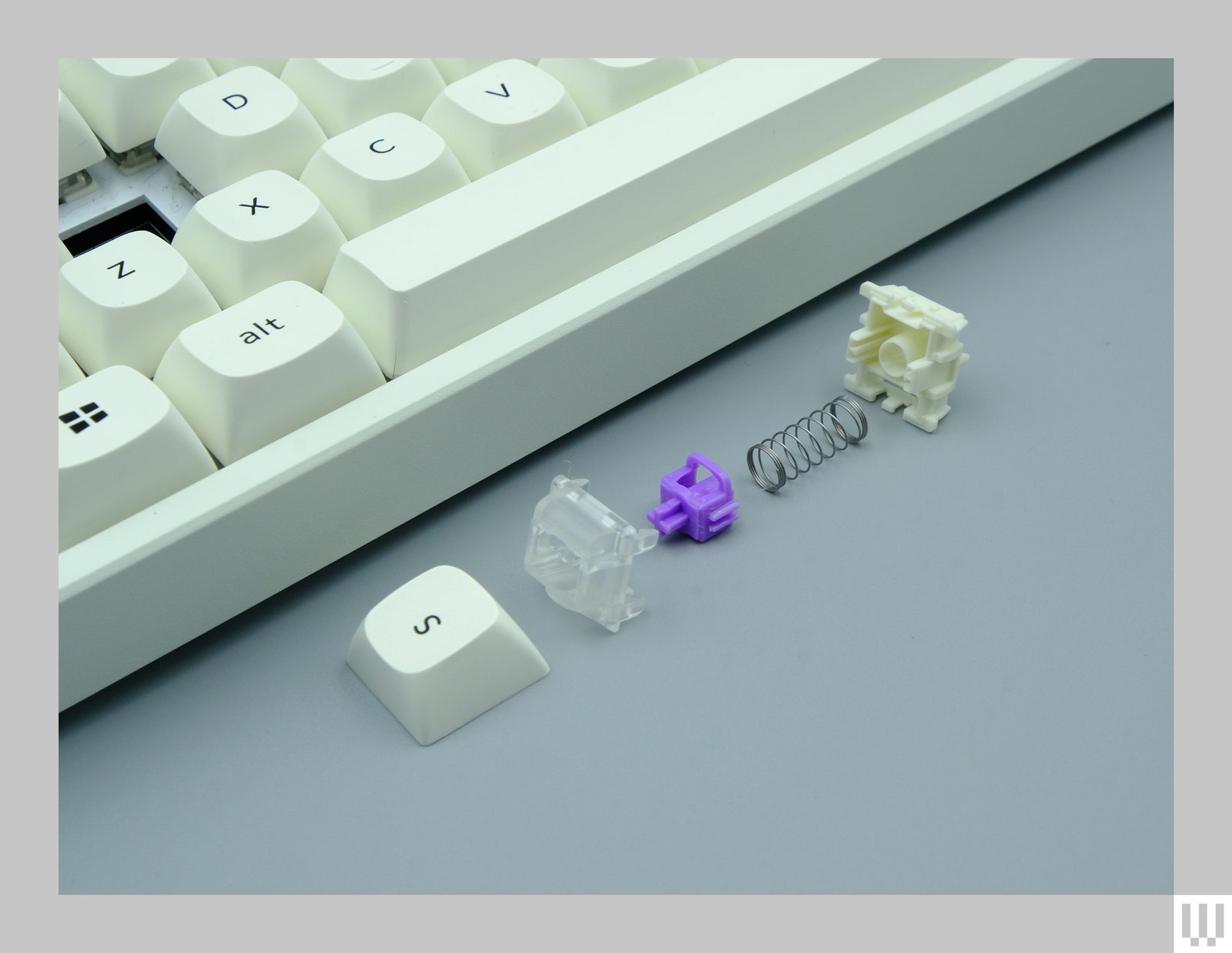 Closeup of the spring and components that make up a keybutton for the Keychron K2 a computer keyboard with white buttons...