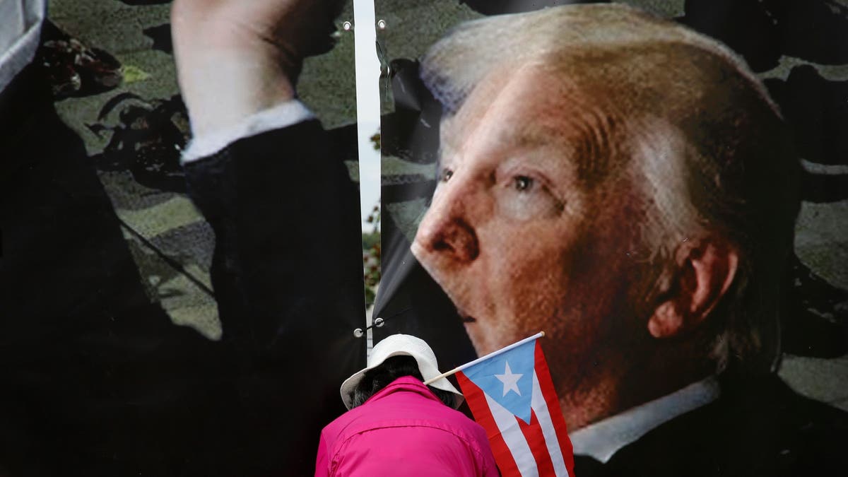 A demonstrator with a Puerto Rican flag attends a rally to protest against Donald Trump on June 18, 2019, in Orlando, Fla.