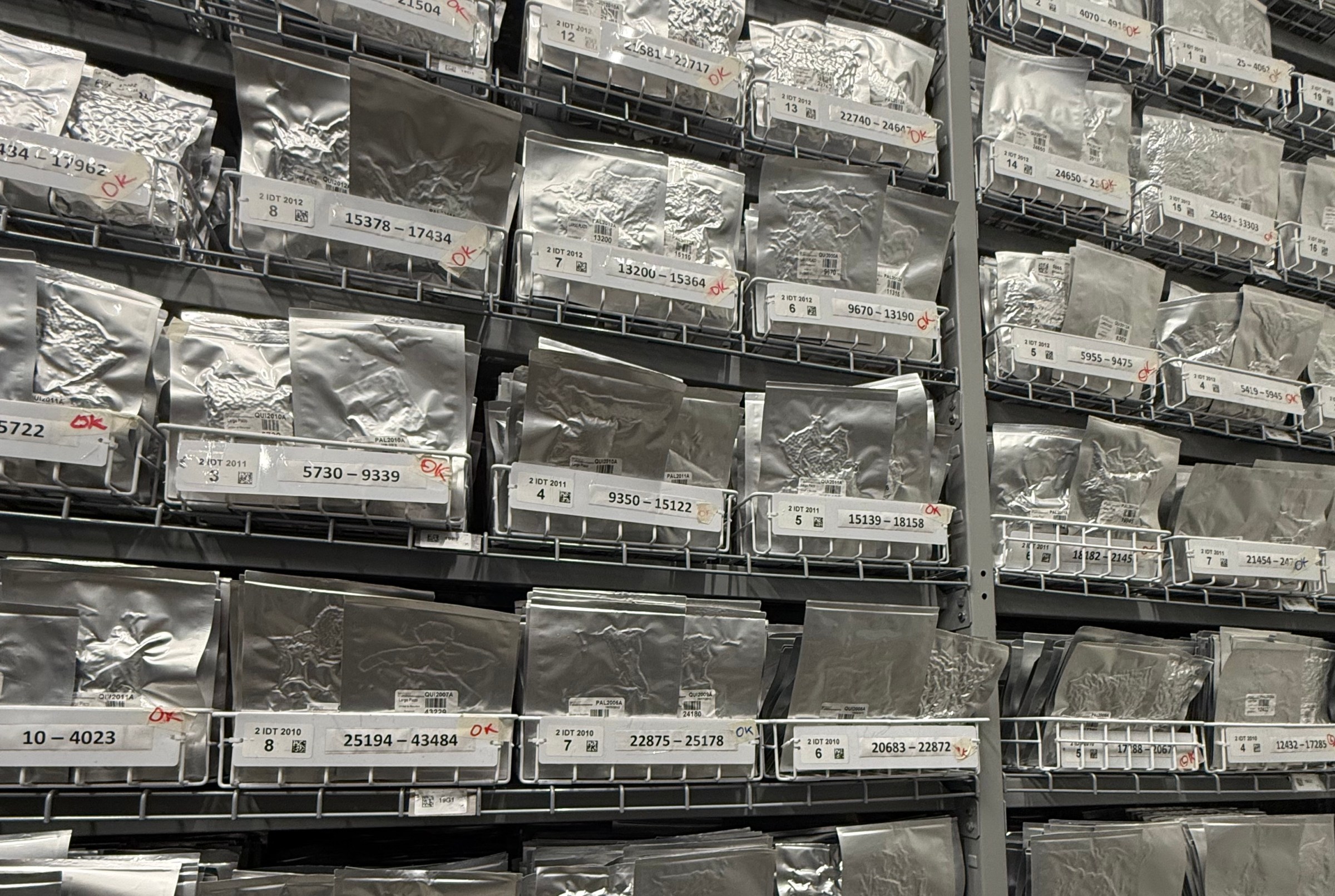 Silver foil packets on wire shelves with numerical labels.