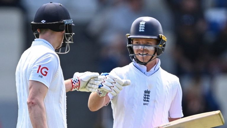 England's Ollie Pope, right, gestures to teammate Harry Brook during play on day one of the second cricket test between New Zealand and England at the Basin Reserve in Wellington, New Zealand, Friday, Dec.6, 2024. (Andrew Cornaga/Photosport via AP)